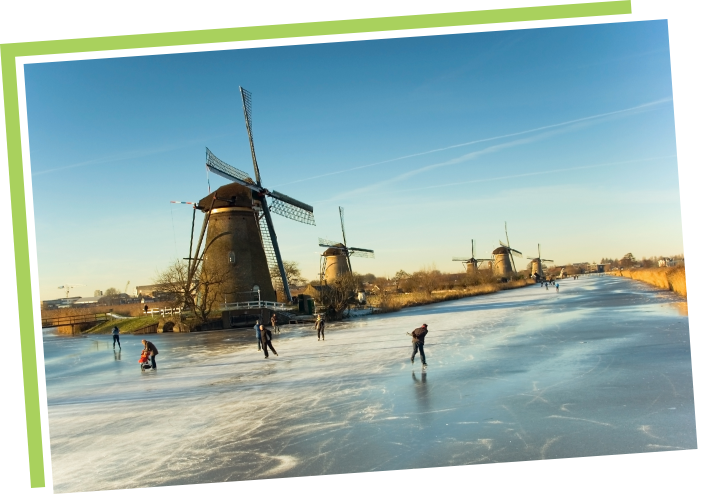 windmill by frozen river with children skating